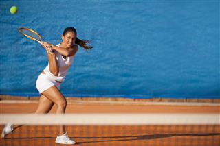Female Tennis Player Hitting The Ball