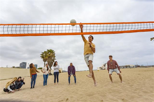 Man Jumping While Playing Beach Volleyball
