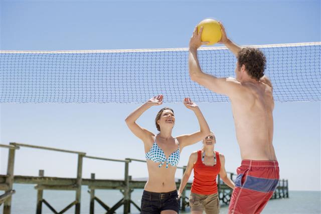 Friends Playing Volleyball On Beach