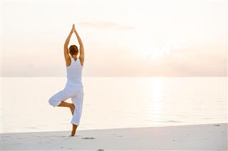 Caucasian Woman Practicing Yoga At Seashore