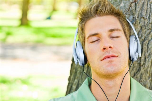 Young Man Listening Music In Park