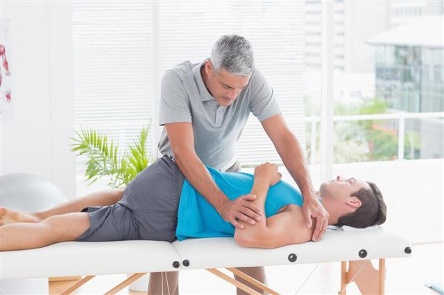 Doctor Stretching Young Man Back