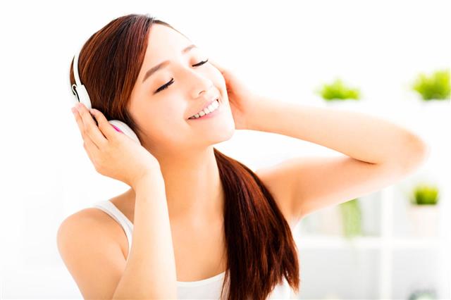 Relaxed Young Woman Listening Music