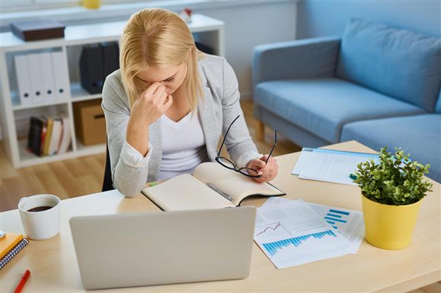 Stressed Businesswoman Working With Laptop