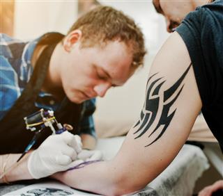 Tattoo master making tattoo