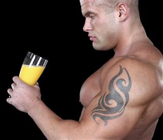 Muscular man drinking juice