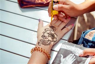 Applying temporary henna tattoo