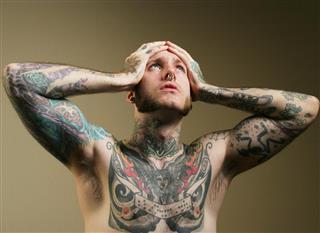 Man with tattoos having headache