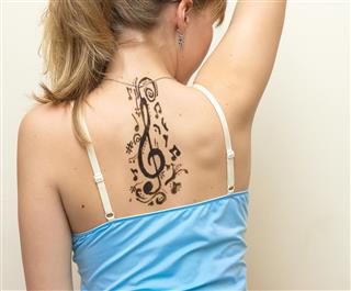 Music symbol tattoo on back