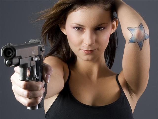 Tattooed girl with gun