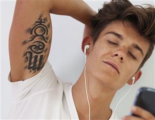 Handsome Man With Tattoo Relaxing During Listening To Music