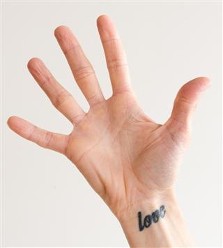 Open hand with wrist tattoo