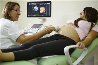 Doctor Performing Ultrasound On Pregnant Woman