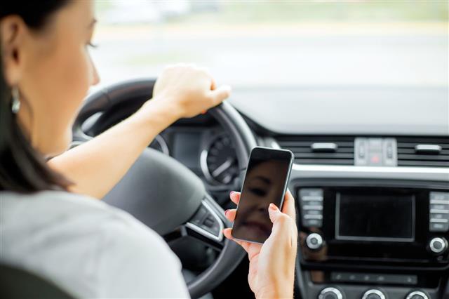 Woman Driving And Looking At Cellphone