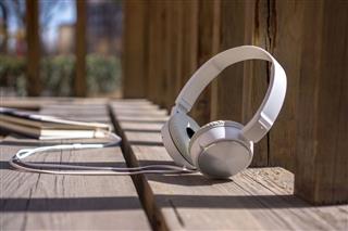 Earphone And Book On Park Bench