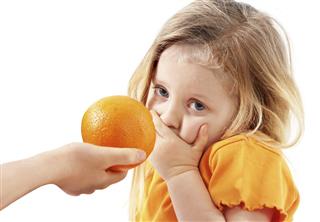 The whimsical child doesn't want to eat orange