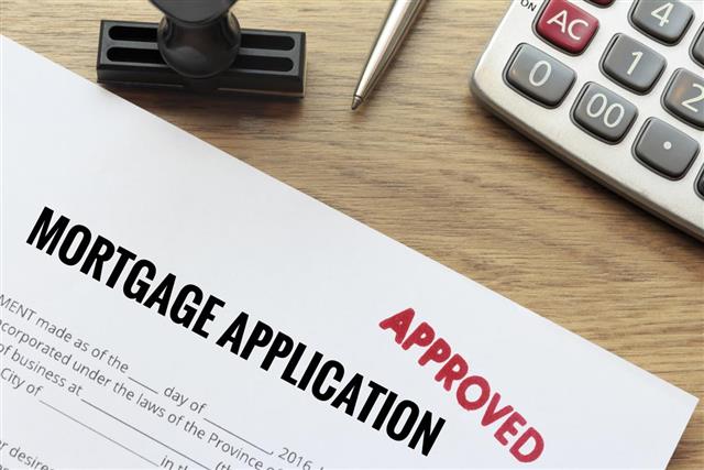 Approved mortgage application form lay down on wooden desk