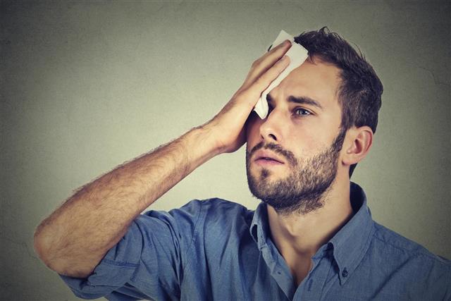 Tired man stressed sweating having fever headache