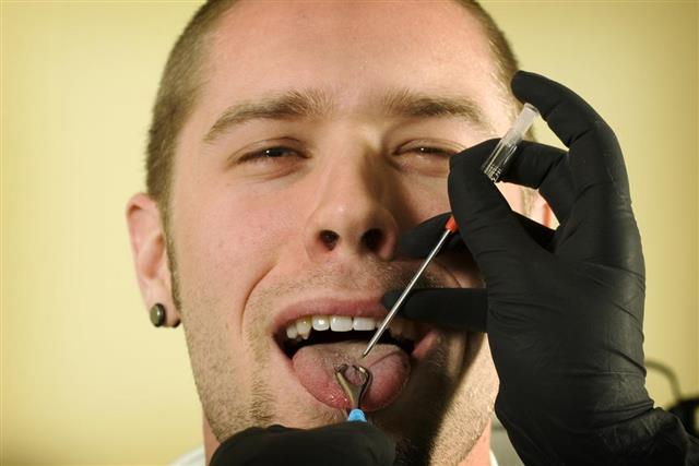Young man about to have tongue pierced