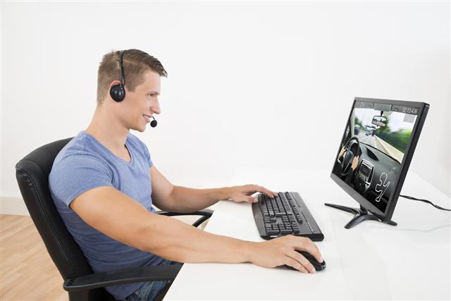 Man With Headset Playing Game On Computer