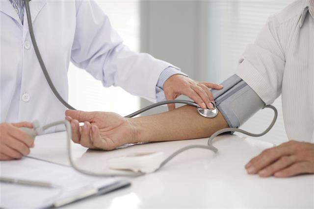 Doctor checking patients blood pressure on right arm