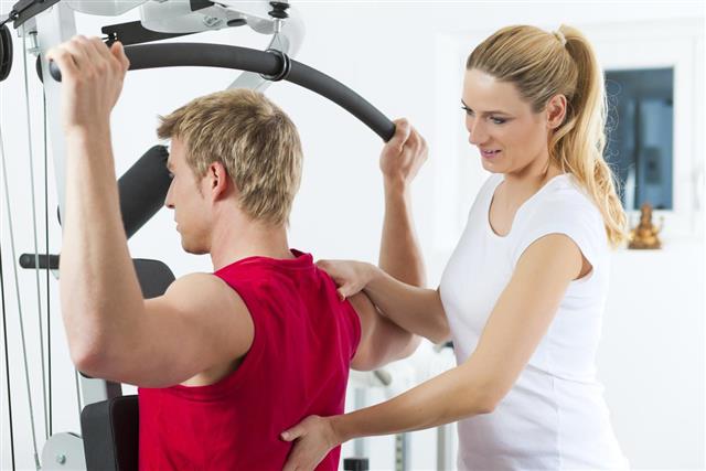 A woman helping a man during physiotherapy