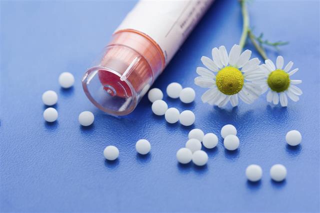 Pills and flowers representing homeopathic medication