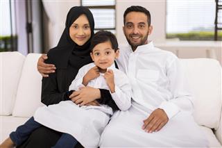 Muslim family sitting on the couch
