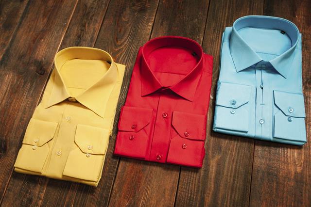 Colorful men's shirts on a wooden background