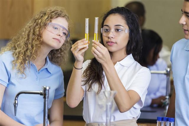 High school students using test tubes during science class experiment