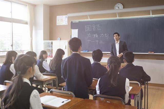 Japanese student stand answering a question to his teacher