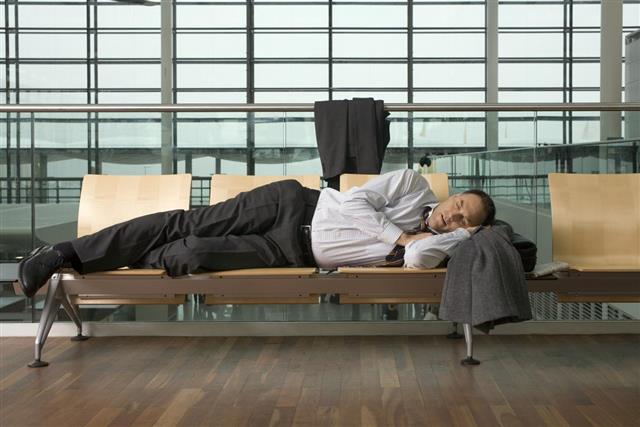 Businessman asleep in airport lounge
