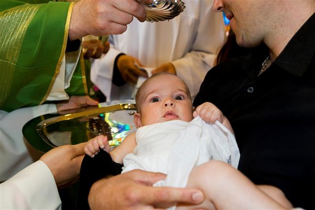 In church...Priest is baptizing little baby