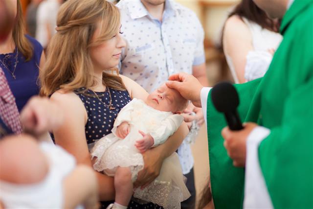 other hold baby on ceremony of child christening in church