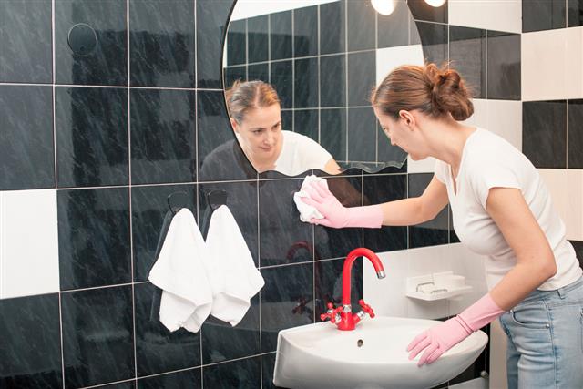 Woman Cleaning Bathroom Tiles