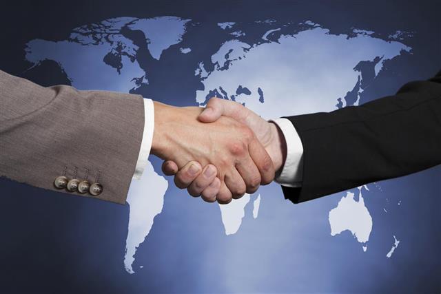 Businessmen Shaking Hands Against Worldmap