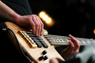 Close-up of an electric bass player's hands
