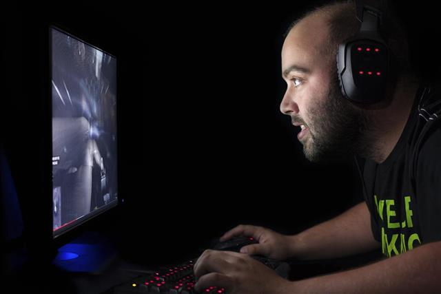 Gamer playing first person shooter game on high end pc