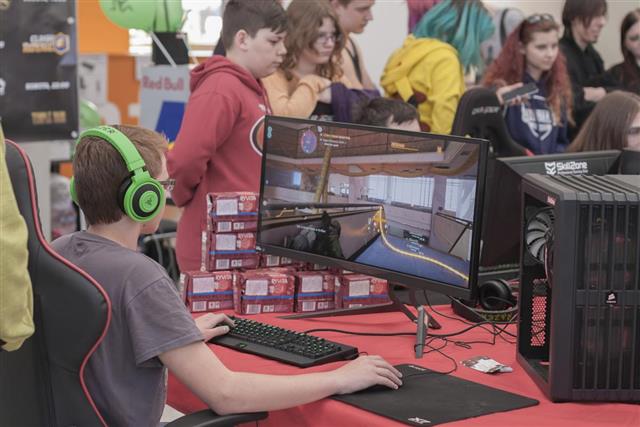 Young boy play game on personal computer at Animefest