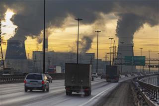 Air pollution from factory with cars on road