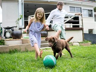 Family playing football with the dog