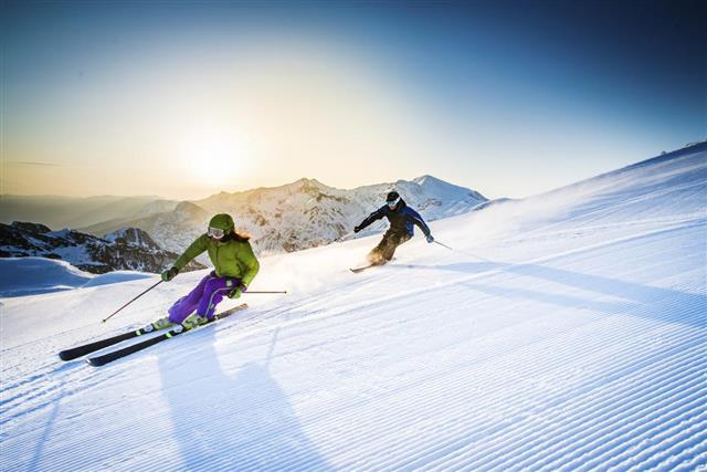 Man and woman skiing downhill