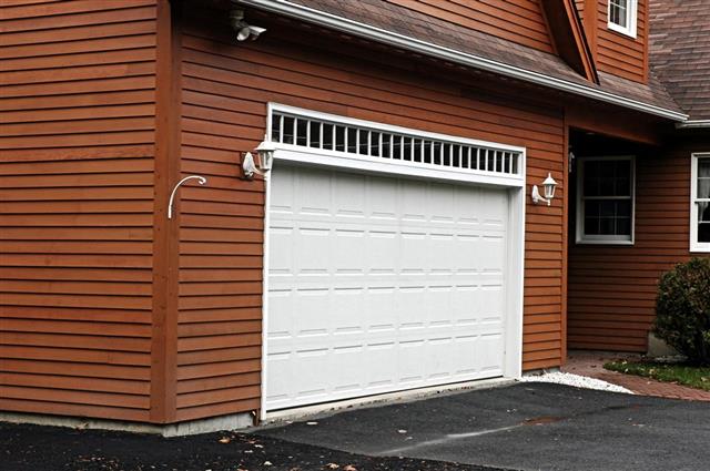 White garage door on a house with wooden siding