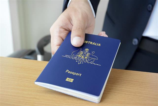 Hands giving passport of Australia