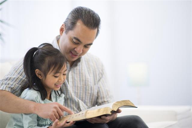 Father and Daughter Reading a Bible Together