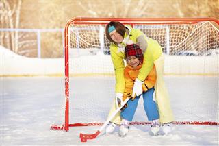 Mom teach boy to play ice hockey