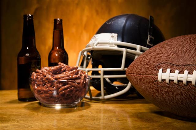 Sports: Football helmet ball on table. Pretzels and beer. Superbowl