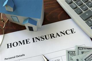 Home insurance form and dollars on the table