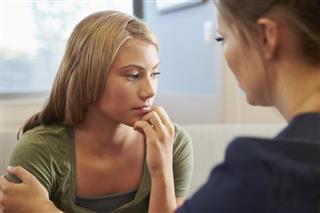 Nurse Treating Teenage Girl Suffering With Depression
