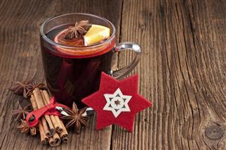 Mulled wine in a glass on old wooden background